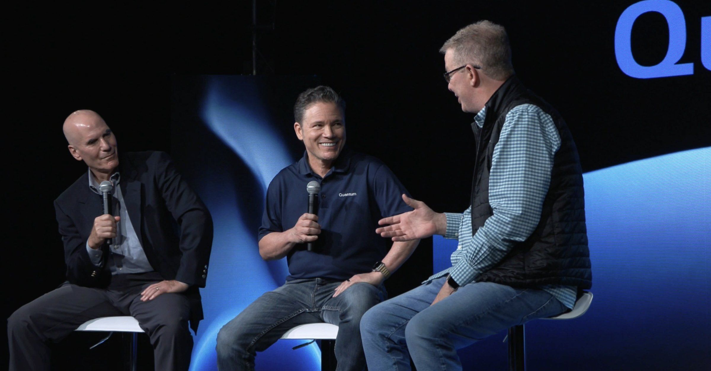 Skip Levens (center), Marc Staimer of Dragonslayer, and Greg Knieriemen of Quantum at launch of Quantum ADM: three speakers on stools with microphones, in front of a blue backdrop.